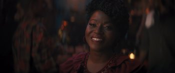Movie still from “Haunted Mansion” (2023), directed by Justin Simien – A person smiling at the camera; Close Up shot, Over the shoulder angle
