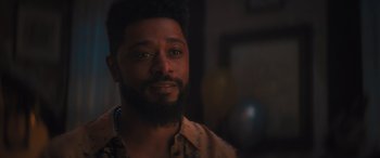 Movie still from “Haunted Mansion” (2023), directed by Justin Simien – A person with a beard looking at the camera; Close Up shot, Over the shoulder angle