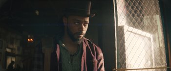 Movie still from “Haunted Mansion” (2023), directed by Justin Simien – A man with a hat and a beard looking out a window; Close Up shot, Low angle