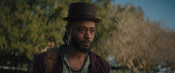 Movie still from “Haunted Mansion” (2023), directed by Justin Simien – A man wearing a hat and a necklace; Close Up shot, Low angle