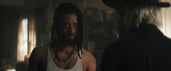 Movie still from “Haunted Mansion” (2023), directed by Justin Simien – A man with dreads is looking at a woman; Close Up shot, Over the shoulder angle