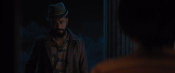 Movie still from “Haunted Mansion” (2023), directed by Justin Simien – A man wearing a hat standing in front of a mirror; Close Up shot, Over the shoulder angle
