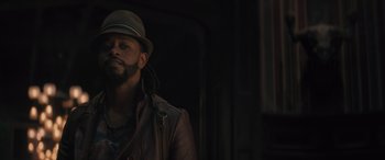 Movie still from “Haunted Mansion” (2023), directed by Justin Simien – A man wearing a hat and a leather jacket; Close Up shot, Over the shoulder angle