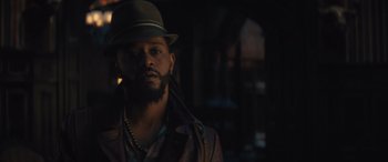 Movie still from “Haunted Mansion” (2023), directed by Justin Simien – A man with a beard wearing a hat and a jacket; Close Up shot, Low angle