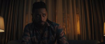 Movie still from “Haunted Mansion” (2023), directed by Justin Simien – A person wearing a shirt; Close Up shot, Over the shoulder angle