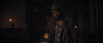 Movie still from “Haunted Mansion” (2023), directed by Justin Simien – A man in a hat and a leather jacket; Close Up shot, Over the shoulder angle