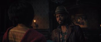 Movie still from “Haunted Mansion” (2023), directed by Justin Simien – A man wearing a hat and a leather jacket; Close Up shot, Over the shoulder angle