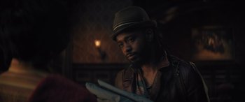 Movie still from “Haunted Mansion” (2023), directed by Justin Simien – A man in a hat is holding something in his hand; Close Up shot, Over the shoulder angle