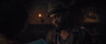 Movie still from “Haunted Mansion” (2023), directed by Justin Simien – A man with a hat and a beard looking to his left; Close Up shot, Over the shoulder angle