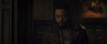 Movie still from “Haunted Mansion” (2023), directed by Justin Simien – A man with a beard and a leather jacket is posing for a picture; Close Up shot, Over the shoulder angle