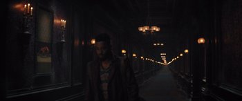Movie still from “Haunted Mansion” (2023), directed by Justin Simien – A man walking down a dark hallway at night; Wide shot, Low angle