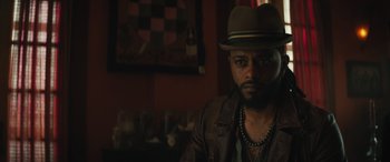 Movie still from “Haunted Mansion” (2023), directed by Justin Simien – A man in a hat and a brown leather jacket; Close Up shot, Over the shoulder angle