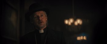 Movie still from “Haunted Mansion” (2023), directed by Justin Simien – A man wearing a black hat and a black suit; Close Up shot, Low angle