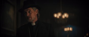 Movie still from “Haunted Mansion” (2023), directed by Justin Simien – A man wearing a black hat and a black suit; Close Up shot, Low angle