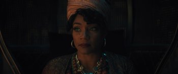 Movie still from “Haunted Mansion” (2023), directed by Justin Simien – A woman wearing a head scarf and wearing a necklace; Close Up shot, Low angle