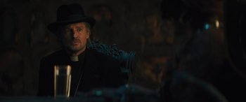 Movie still from “Haunted Mansion” (2023), directed by Justin Simien – A man wearing a black hat and a black coat; Close Up shot, Over the shoulder angle