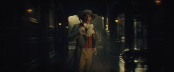 Movie still from “Haunted Mansion” (2023), directed by Justin Simien – A man in a suit and hat standing in a dark hallway; Medium shot, Low angle
