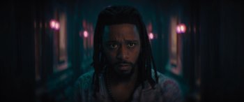 Movie still from “Haunted Mansion” (2023), directed by Justin Simien – A person with dreadlocks looking at the camera; Close Up shot, Low angle