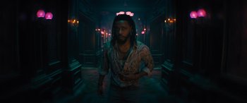 Movie still from “Haunted Mansion” (2023), directed by Justin Simien – A man with dreadlocks walking down a dark hallway; Medium shot, Low angle