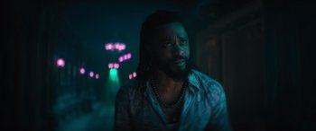 Movie still from “Haunted Mansion” (2023), directed by Justin Simien – A man with dreadlocks is looking into the distance; Medium shot, Low angle