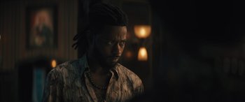 Movie still from “Haunted Mansion” (2023), directed by Justin Simien – A person with dreadlocks looking at the camera; Close Up shot, Over the shoulder angle