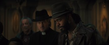 Movie still from “Haunted Mansion” (2023), directed by Justin Simien – A man in a hat is next to another man in a hat; Close Up shot, Low angle