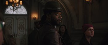 Movie still from “Haunted Mansion” (2023), directed by Justin Simien – A man in a hat and a leather jacket looking to his left; Close Up shot, Over the shoulder angle