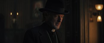 Movie still from “Haunted Mansion” (2023), directed by Justin Simien – A man wearing a black hat and a black suit; Close Up shot, Low angle