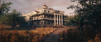 Movie still from “Haunted Mansion” (2023), directed by Justin Simien – An old house with a fence in front of it; Extreme Wide shot, Low angle