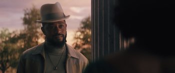 Movie still from “Haunted Mansion” (2023), directed by Justin Simien – A man with a beard and a hat is standing in front of a window; Close Up shot, Over the shoulder angle