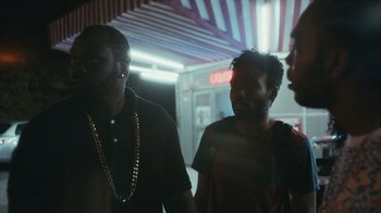 Movie still from “Atlanta” (2016), created by Donald Glover – A group of men standing next to each other; Medium shot, Over the shoulder angle