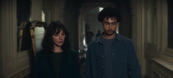 Movie still from “Heart of Stone” (2023), directed by Tom Harper – A man and a woman standing next to each other; Medium shot, High angle