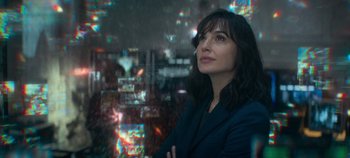 Movie still from “Heart of Stone” (2023), directed by Tom Harper – A woman standing in front of a window with lights; Close Up shot, Over the shoulder angle