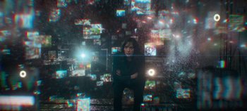 Movie still from “Heart of Stone” (2023), directed by Tom Harper – A woman standing in front of a bunch of tv screens; Wide shot, High angle