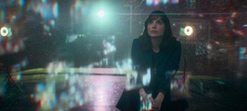 Movie still from “Heart of Stone” (2023), directed by Tom Harper – A woman sitting on a bench looking out a window; Medium shot, Low angle