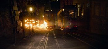 Movie still from “Heart of Stone” (2023), directed by Tom Harper – Two trolleys are on a street at night; Extreme Wide shot, High angle