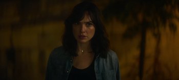 Movie still from “Heart of Stone” (2023), directed by Tom Harper – A woman in a black shirt is looking at the camera; Close Up shot, Over the shoulder angle