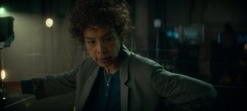 Movie still from “Heart of Stone” (2023), directed by Tom Harper – A woman in a jacket is looking at the camera; Close Up shot, Over the shoulder angle