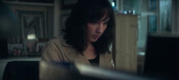 Movie still from “Heart of Stone” (2023), directed by Tom Harper – A woman sitting in front of a computer screen; Close Up shot, High angle