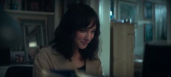 Movie still from “Heart of Stone” (2023), directed by Tom Harper – A person sitting at a table; Close Up shot, Over the shoulder angle