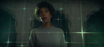 Movie still from “Heart of Stone” (2023), directed by Tom Harper – A woman standing in front of a mirror; Medium shot, Low angle