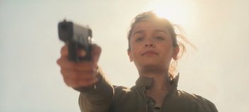 Movie still from “Heart of Stone” (2023), directed by Tom Harper – A woman is holding a gun up to her face; Close Up shot, Low angle