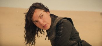 Movie still from “Heart of Stone” (2023), directed by Tom Harper – A person with long black hair; Close Up shot, Over the shoulder angle