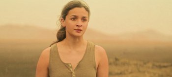 Movie still from “Heart of Stone” (2023), directed by Tom Harper – A woman in a brown tank top is looking at the camera; Close Up shot, Low angle