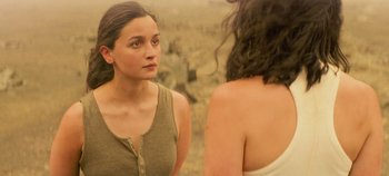 Movie still from “Heart of Stone” (2023), directed by Tom Harper – A woman looking into a mirror while standing next to another woman; Close Up shot, Over the shoulder angle