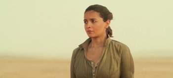 Movie still from “Heart of Stone” (2023), directed by Tom Harper – A woman standing in the desert looking to her left; Close Up shot, Over the shoulder angle
