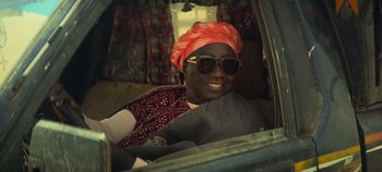 Movie still from “Heart of Stone” (2023), directed by Tom Harper – A woman with a turban and sunglasses sitting in a car; Close Up shot, Low angle