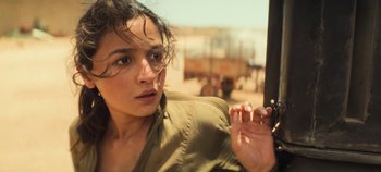 Movie still from “Heart of Stone” (2023), directed by Tom Harper – A woman holding a cell phone in her hand; Close Up shot, Over the shoulder angle