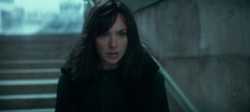 Movie still from “Heart of Stone” (2023), directed by Tom Harper – A person with long black hair; Close Up shot, Over the shoulder angle