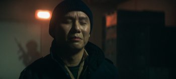 Movie still from “Heart of Stone” (2023), directed by Tom Harper – A man in a black jacket and a black hat; Close Up shot, Low angle